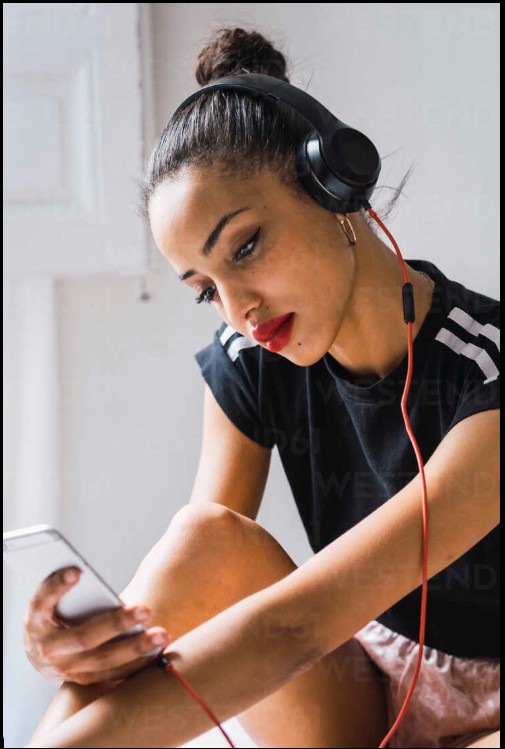 melodii care nu iti ies din minte – persoana cu casti ascultand muzica si gandindu-se intens