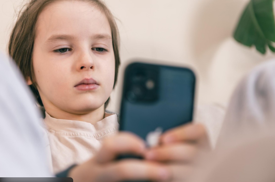 copilul sta prea mult pe telefon – copil folosind telefonul mobil